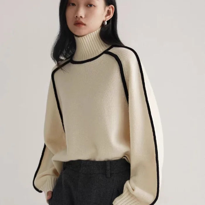 Women's Half Turtleneck Sweater in ivory with high collar and black edging, worn with formal grey pants.
