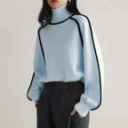 Light blue Women's Half Turtleneck Sweater with black trim, styled with charcoal trousers for winter look.