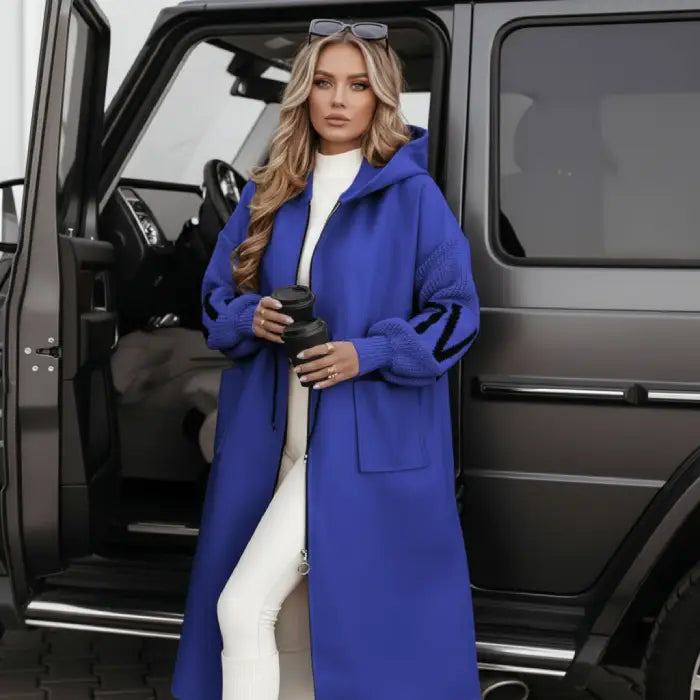 Women’s long hooded cardigan coat in striking blue styled by SUV, warm knit sleeves delivering bold comfort ideal for elevated streetwear