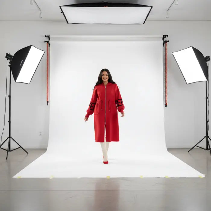 Women’s long hooded cardigan coat in bold red modeled in studio, knit sleeves adding warm comfort and standout color for seasonal style