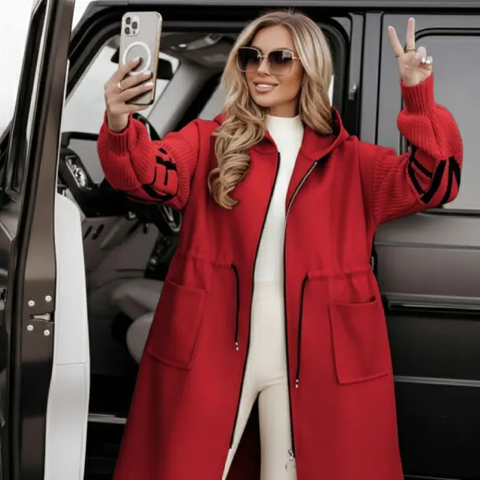 Women’s long hooded cardigan coat in bold red styled beside a vehicle, textured sleeves adding luxe warmth for elevated street style appeal