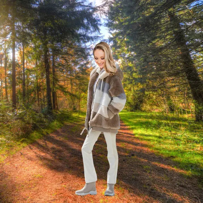 Womens loose plush coat in soft neutral colors styled in a forest setting.