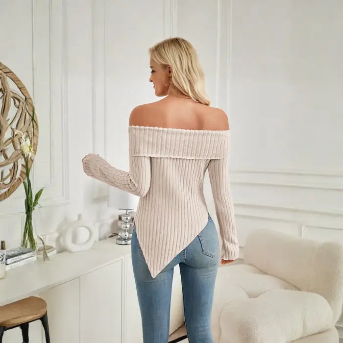 Back view of women's off shoulder knit top in beige with ribbed texture and pointed hemline.