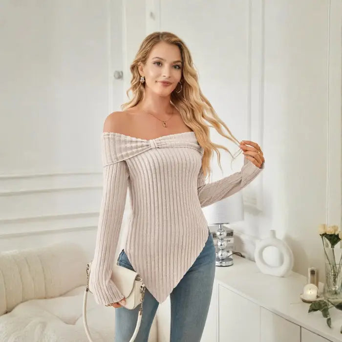 Model smiling in beige women's off shoulder knit top styled with waves and gold accessories.