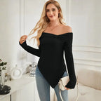 Women's off shoulder knit top styled in black with minimal accessories and blue jeans.