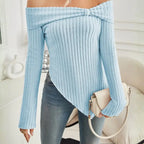 Close-up of light blue off shoulder knit top styled with neutral purse and casual jeans.