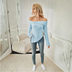 Full view of light blue off shoulder knit top styled with skinny jeans and white sneakers indoors.