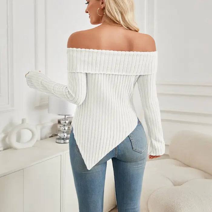 Back view of women's white off shoulder knit top showing ribbed knit and asymmetrical hemline.