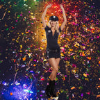 Women's police officer costume model celebrating on a confetti-covered dance floor with arms raised.