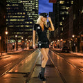 Women's police officer costume worn in city at night with streetlights and tall buildings in the background.