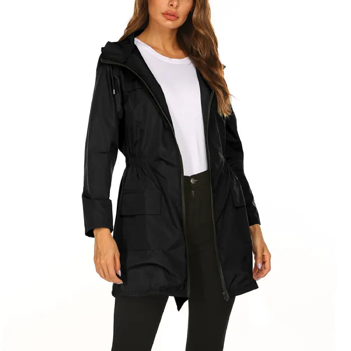 Womens raincoat in black with front zipper and pockets worn over a white top.
