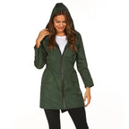 Womens raincoat in dark green featuring a hood and front zipper worn casually.