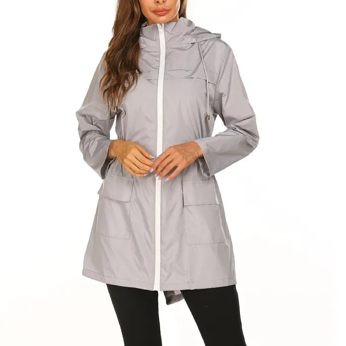 Womens raincoat in gray with hood and white zipper trim.