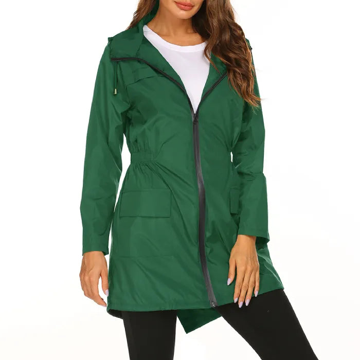 Womens raincoat in green with front zipper and pockets worn over a white top.