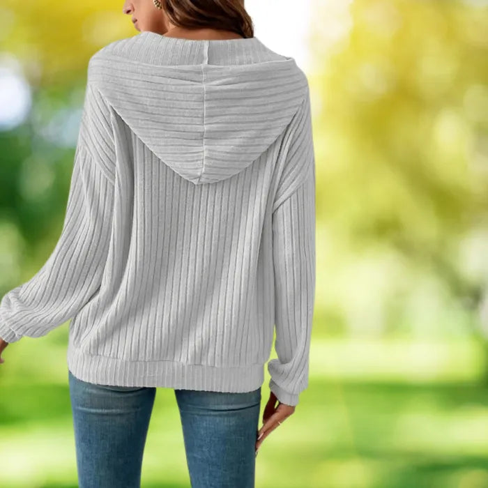 Women's Ribbed Hoodie shown from the back in a bright, green outdoor spring setting.