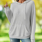 Women's Ribbed Hoodie close-up showing drawstring hood and kangaroo pocket in a park setting.