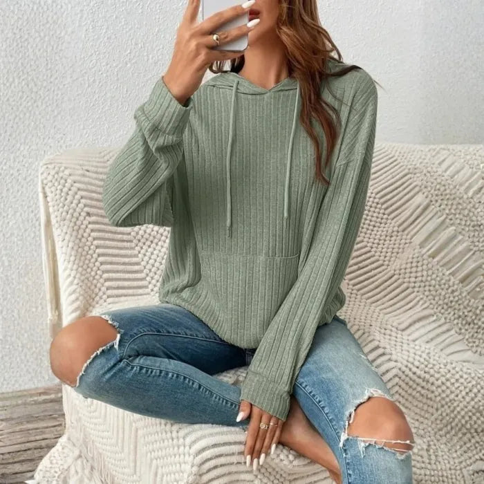 Women's Ribbed Hoodie in sage green styled indoors with distressed jeans and cozy knit blanket.
