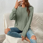 Women's Ribbed Hoodie in sage green styled indoors with distressed jeans and cozy knit blanket.