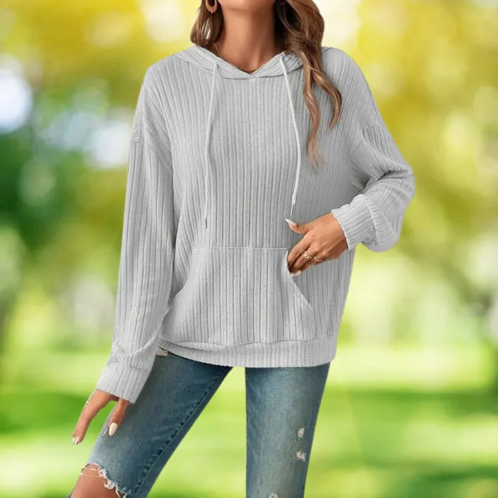 Women's Ribbed Hoodie in light gray shown front-facing in an outdoor park setting with blurred trees.