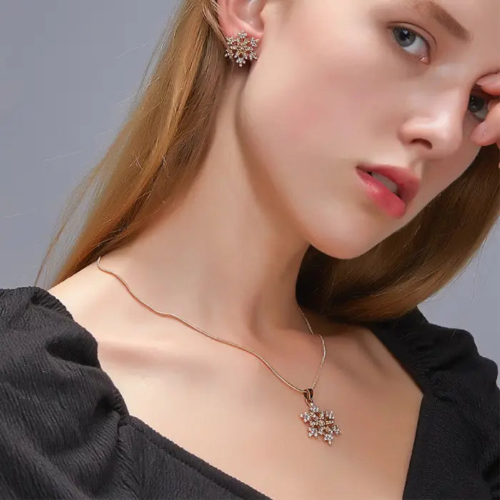 Women’s snowflake necklace and earring set worn by model, featuring sparkling crystal snowflakes for elegant winter and holiday style