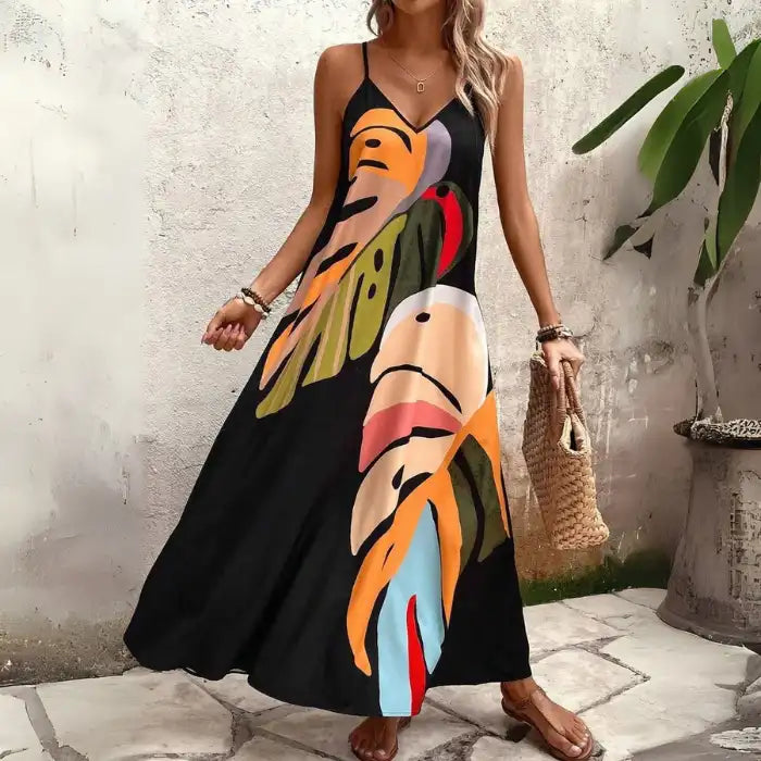 Women's tropical leaf print maxi dress in black with colorful oversized leaf design and thin straps.