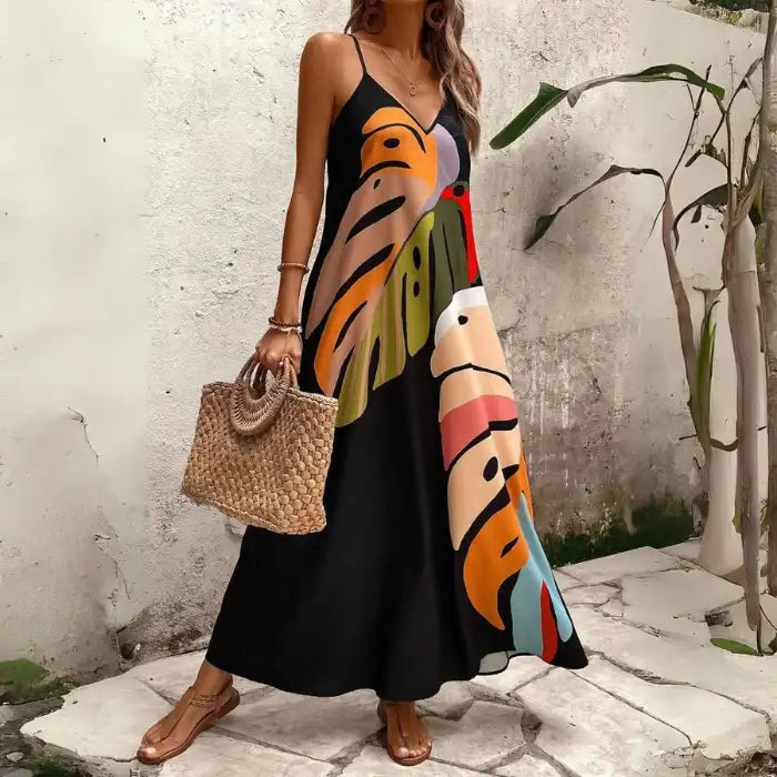 Women's tropical leaf print maxi dress with flared hem and bold, oversized botanical design.