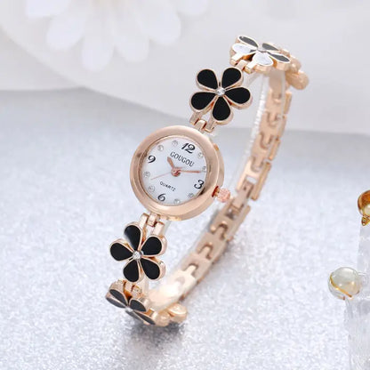 Women's watch bracelet set with black flower design and rose gold accents.