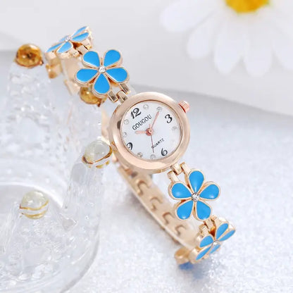 Women's watch bracelet set with blue flower design and rose gold accents.