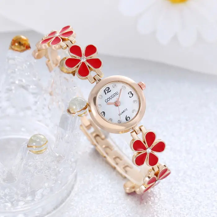 Women's watch bracelet set with red flower design and rose gold finish.