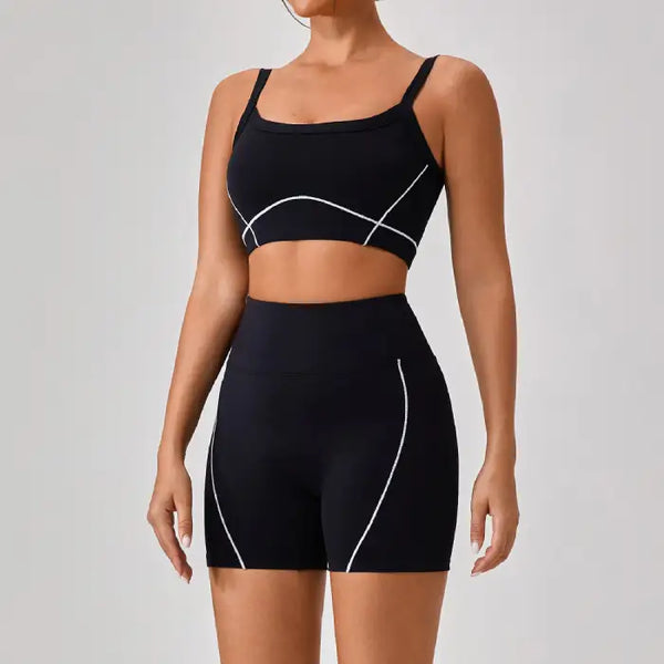 Women's workout set featuring black sports bra and high-waisted shorts with white contour seams for stylish gym wear
