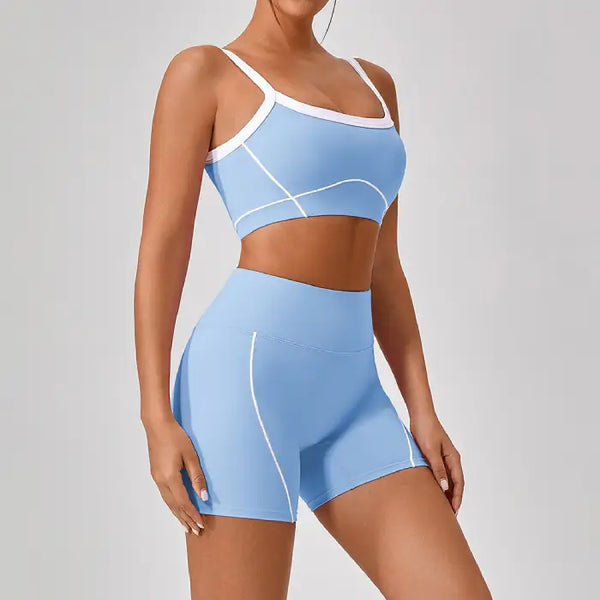 Women's workout set in light blue featuring contour design sports bra and high-waisted biker shorts with white piping