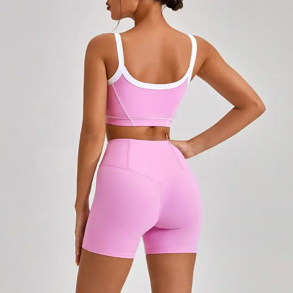 Women's workout set showing back view of pink sports bra with white trim straps and V-shaped design
