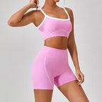 Women's workout set in pink shown from side view featuring square neckline sports bra and high-waisted biker shorts