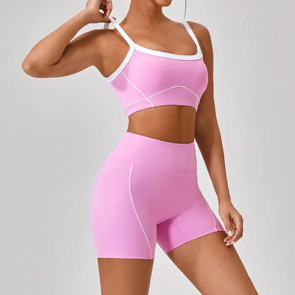 Women's workout set in pink shown from side view featuring square neckline sports bra and high-waisted biker shorts