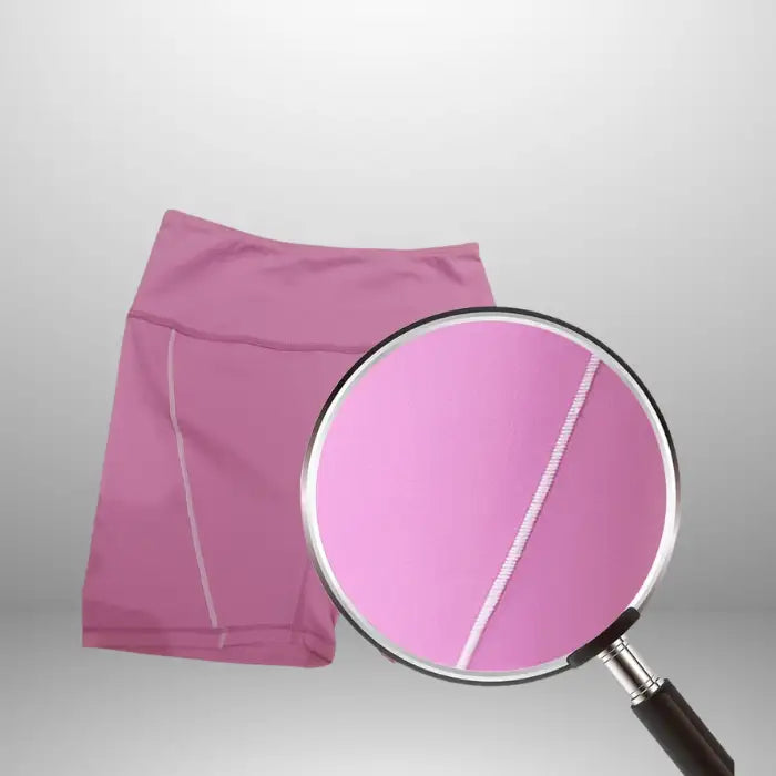 Women's workout set shorts close-up displaying white contrast seam detail on pink high-waisted compression design