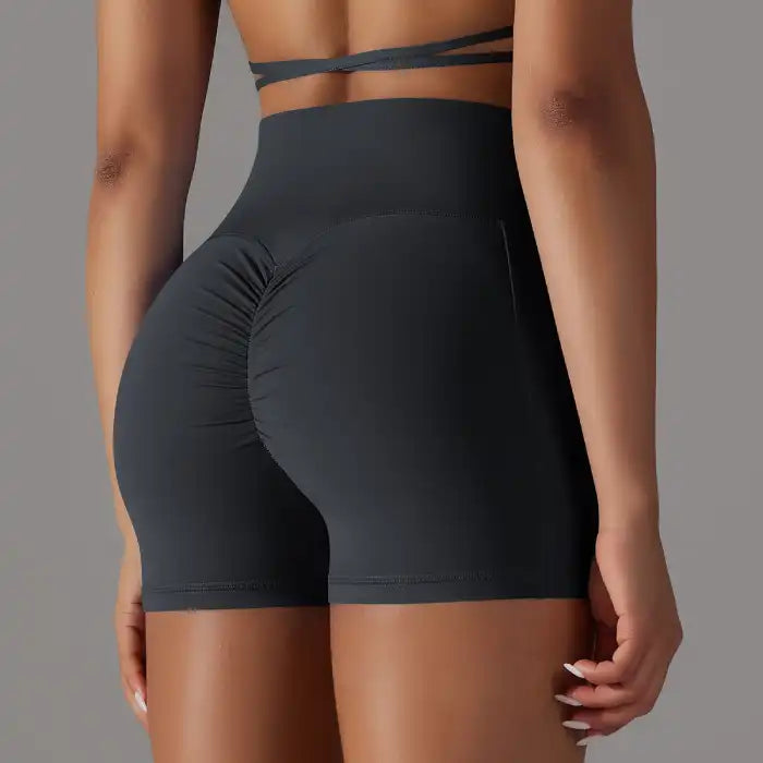 Womens yoga shorts in black with ruched scrunch back detail and high waist for enhanced shape.
