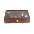 Wooden watch box with a glass display lid showcasing various watches