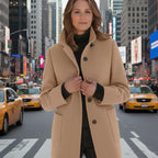 Wool pea coat in camel worn by a woman standing in a busy urban street with taxis.