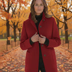 Wool pea coat in deep red worn by a woman in an autumn park with colorful foliage.