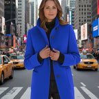 Wool pea coat in royal blue worn by a woman standing in a busy urban street.
