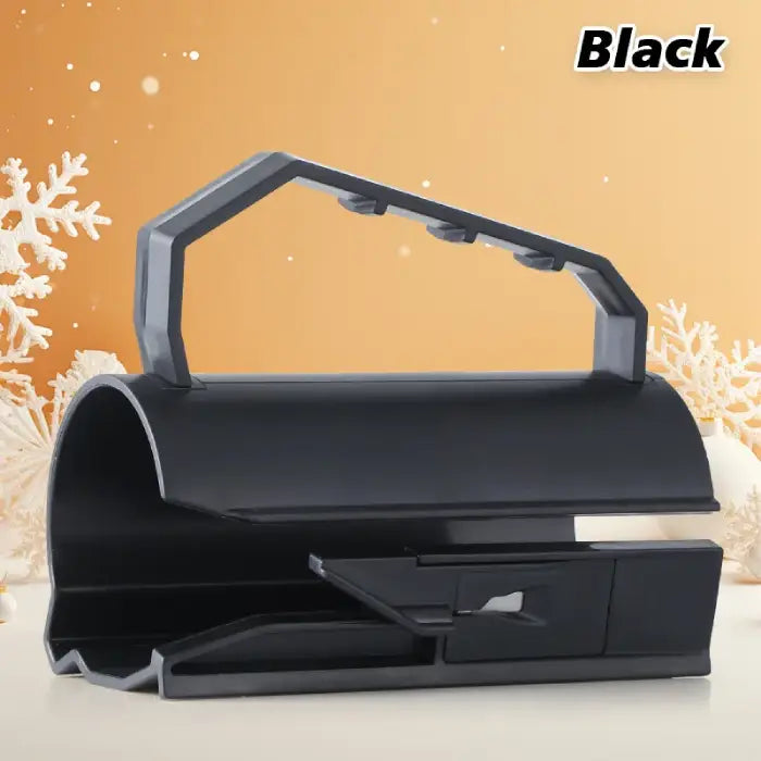 Wrapping paper cutter in black with ergonomic handle and modern design against holiday-themed background.