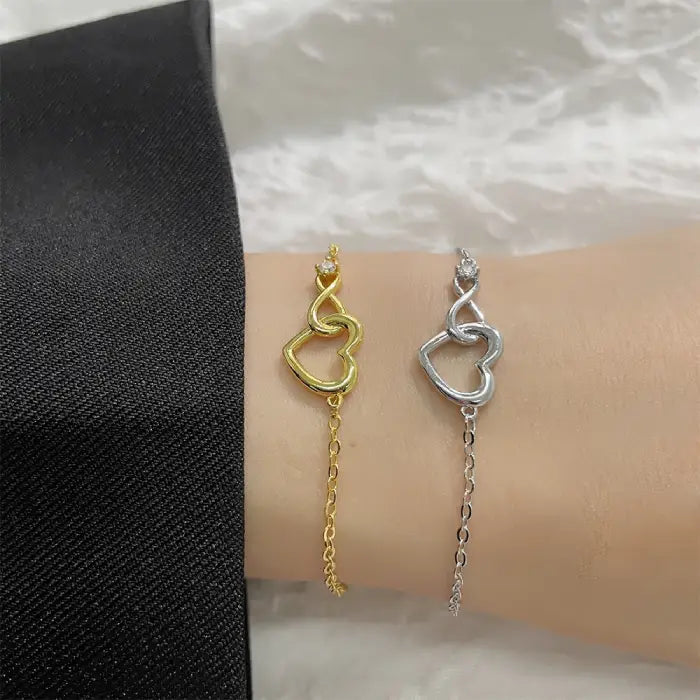 Stylish gold and silver heart infinity bracelets worn together, perfect for gifts and daily wear.