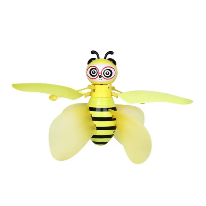 Front-facing view of yellow bee-shaped flying toy with transparent wings and distinctive glasses-like face design features