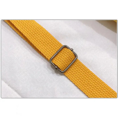 Close-up of yellow canvas strap with metal buckle adjustment detail