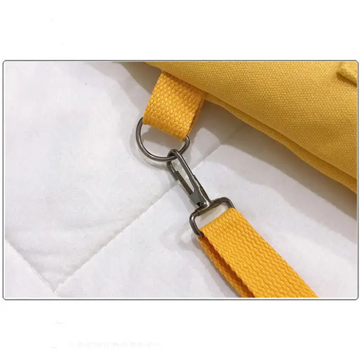 Close-up of yellow canvas strap with metal buckle adjustment detail