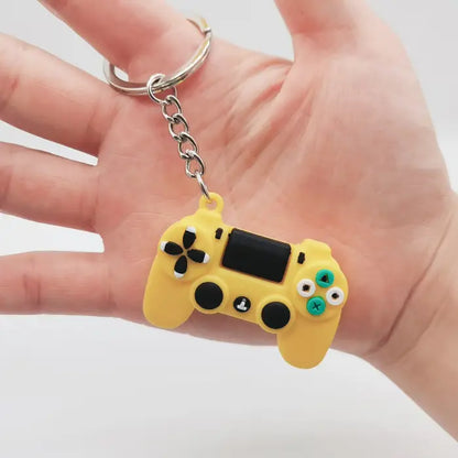 Close-up of a yellow game controller keychain held in hand, a great accessory for gaming enthusiasts.