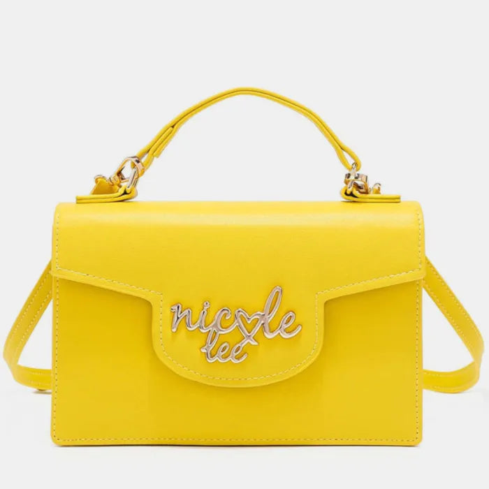 Yellow leather crossbody bag with top handle, flap closure, and silver cursive logo embellishment