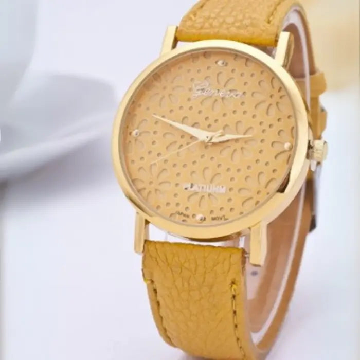 Yellow women's watch with a gold floral-patterned dial and yellow leather strap.