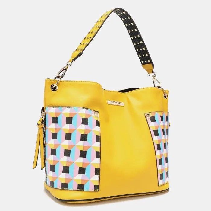 Bright yellow leather handbag with geometric pattern panels, studded strap, and silver hardware details