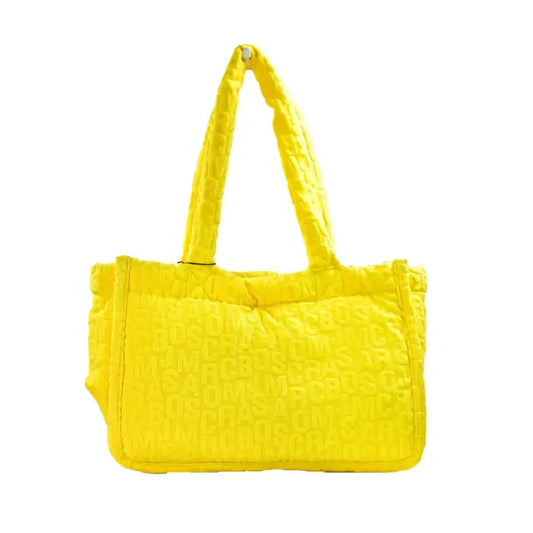 Bright yellow Marc Jacobs tote bag with embossed logo pattern and sturdy handles, perfect for stylish outings.